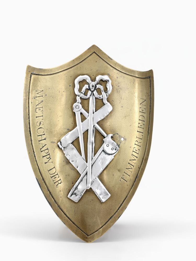 Schild van de gilde van de timmerlieden te Brugge  met op de voorzijde het gereedschap van een timmerman met bovenaan een strik