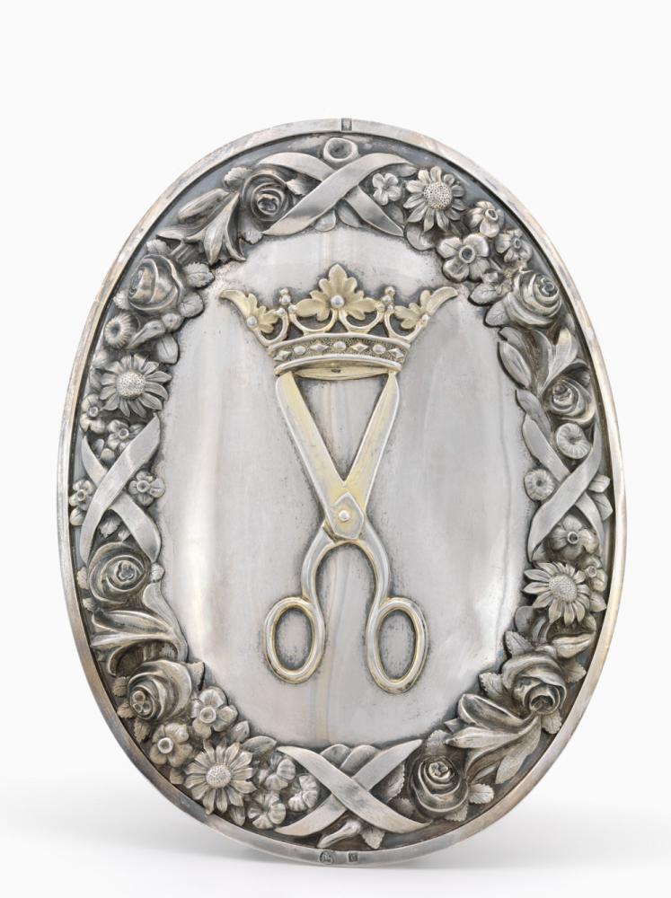 Schild van zilver  gekroonde open schaar met florale omlijsting  embkeem van de gilde van de kleermakers van Brugge