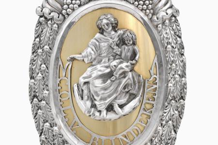 Flambeeuwschild van zilver en verguld zilver. Brugse Confrerie van Onze-Lieve-Vrouw van Blindekens Brugge  ovale schilden met centraal omlijst door florale motieven Maria met kind gezeten op een maansikkel met inscriptie: 'C.O.L.V. Blindekens'. De omlijst